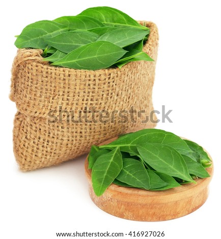 Henna leaves in sack and a wooden bowl over white background