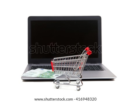 A shopping cart with euro banknotes at notebook
