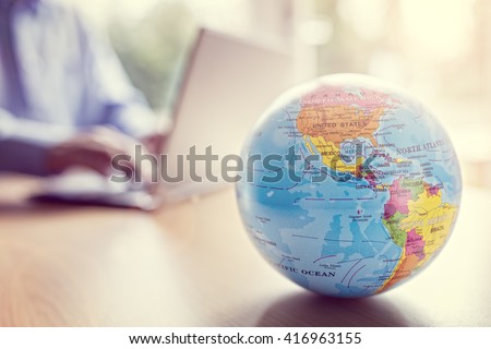 Businessman using a laptop with close up on world globe Royalty-Free Stock Photo #416963155