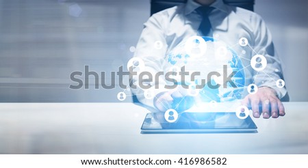 Businessman using tablet with globe and social network. Elements of this image furnished by NASA