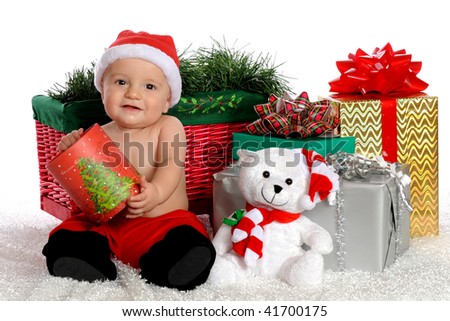 An adorable baby boy holding an opened Christmas box, surrounded  by other gifts.  Isolated on white.