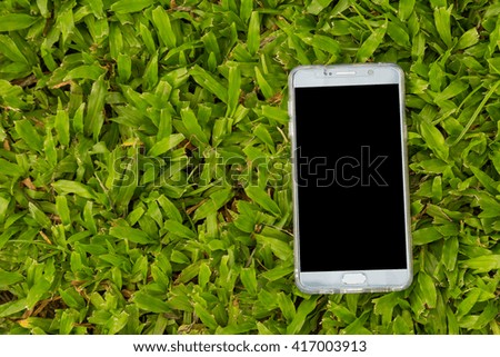 Smart phone on green grass background