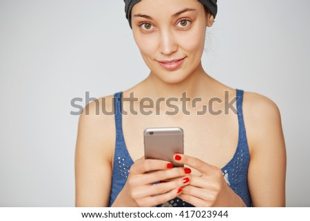 Technology and communication concept. Young female using electronic device at home. Student girl texting groupmates via social networks, isolated against white blank copy space wall. Selective focus