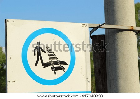 sign pedestrian crossing rail tracks hanging on a pole