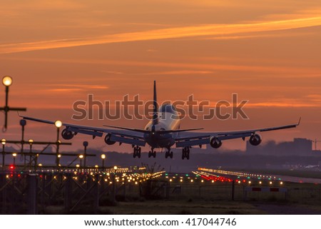 Airplane is flying to the runway during a nice sunrise.