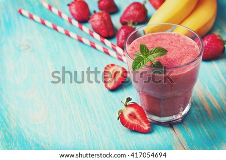 smoothie with banana and strawberry in the glass, fresh strawberries and bananas on the  wooden background (toning) Royalty-Free Stock Photo #417054694