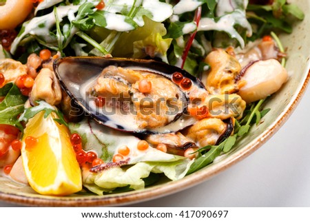 Warm salad with seafood, boiled eggs, lemon, red caviar and raw vegetables. Royalty-Free Stock Photo #417090697