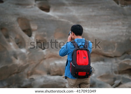 A man asia with backpack taking a photo on the top of mountains ,soft focus