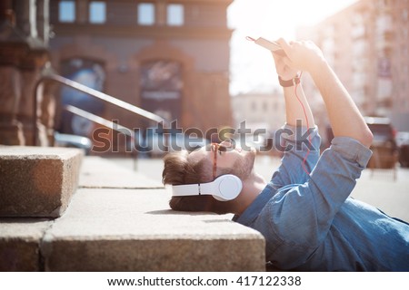Positive guy lying on the footsteps  Royalty-Free Stock Photo #417122338