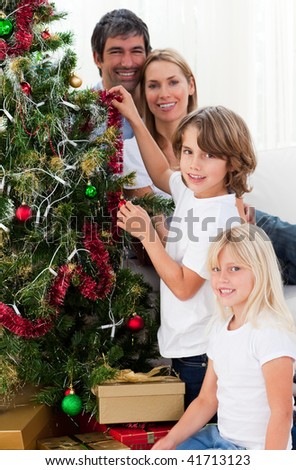 Young family decorating a Christmas tree in the living-room