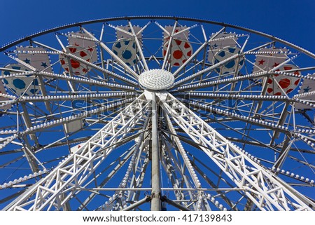 Ferris Wheel decorated in Red and Blue against a Blue Sky