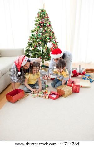 Happy family opening Christmas presents in the living-room