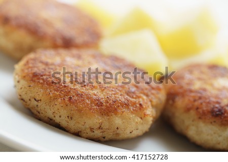 prepared fried fish cakes with boiled potatoes, shallow focus