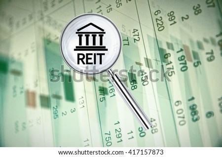 Magnifying lens over background with building icon and text REIT (Real Estate Investment Trust), with the financial data visible in the background. 3D rendering.
