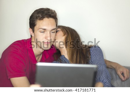 Young couple taking a selfie with a digital tablet at home isolated in a white background. 