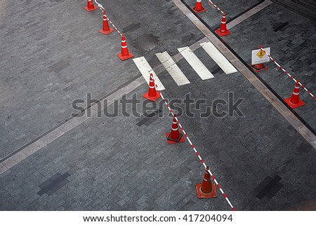Pedestrian crossing and traffic cone on the road. Crosswalk.