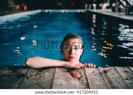 A young pretty woman relaxes in the swimming pool. Wellness concept. Spa and relax, woman happiness.