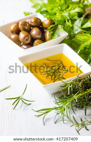 Olive oil olives and fresh herbs on white background. Greek mediterranean cusine concept.