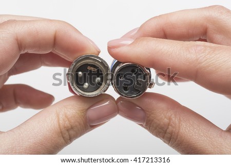 Female hands holding XLR connectors isolated on white
