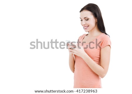 Portrait of stylish beautiful young woman isolated on white background. Woman smiling and using mobile phone. Free space for logo