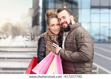 Picture of young couple with shopping bags and credit card in the city