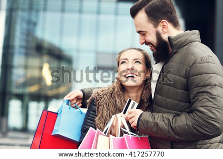 Picture of young couple with shopping bags and credit card in the city 