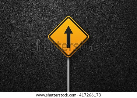 Road sign of the diamond shape with pointer on a background of asphalt. The texture of the tarmac, top view.