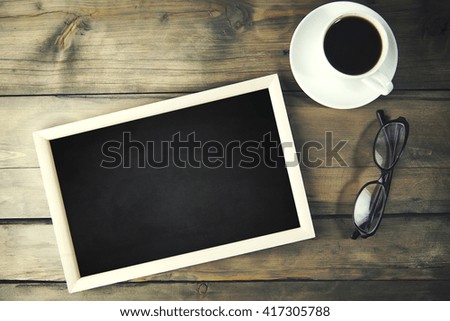Coffee, glasses and photo frames on wooden table