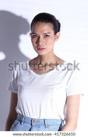 Japanese Housewife in white shirt blue skirt on white background, studio lighting with contrast shadow, silhouette, half body