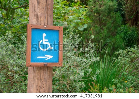 Wheelchair Handicap information Sign in the outdoor green park - Selective focus