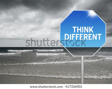 sign at beach with storm background and text think different