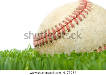 Softball in grass close up isolated on white