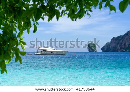 White motor yacht on the background of turquoise water and rocks