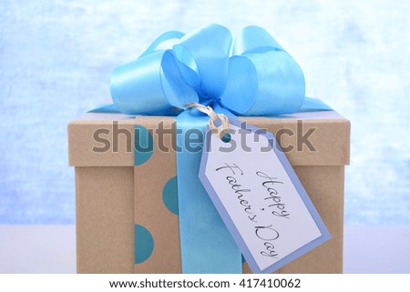 Happy Fathers Day gift close up on white wood table and pale blue background. 