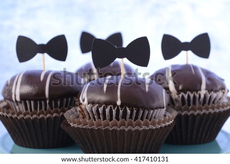 Happy Fathers Day cupcakes on cake stand against a blue background. 