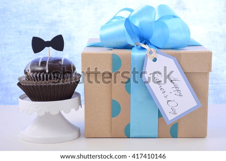 Happy Fathers Day cupcake gift on pale blue and white wood background. 
