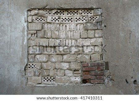Photo concrete wall with a window laid down different bricks