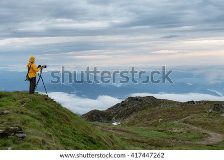 photographer with camera shooting smoky mountains