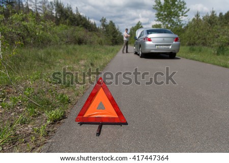 car broken down and a red triangle to warn other road users