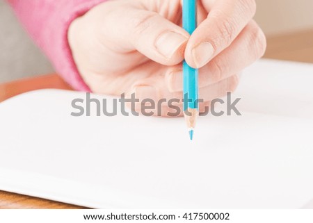 Woman writing in notebook. Conceptual image of office work or education.