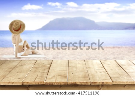 summer landscape of beach and yellow wooden deck and woman and white towel 