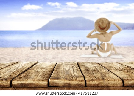 summer landscape of beach and woman on white towel and brown hat and retro old table place 