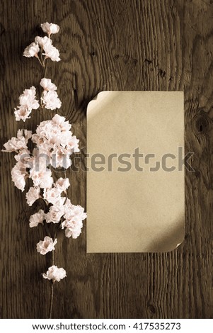 brown paper and pink flowers on wooden background,filter effect.