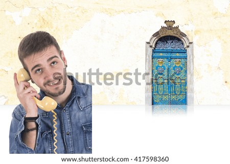 Handsome smiling guy using vintage telephone