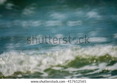 blurred sunlight reflected in the blue sea waves at daytime