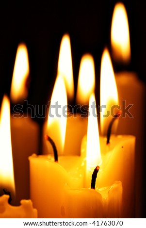 Burning candles close-up over a black background
