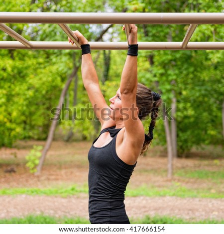 Female athlete crossing monkey bars