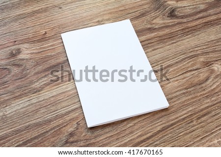 Blank of brochure is on a wooden desk. Template for your design. 