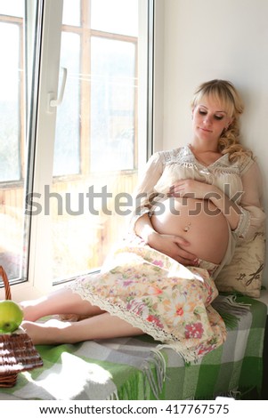 belly pregnant woman near window 