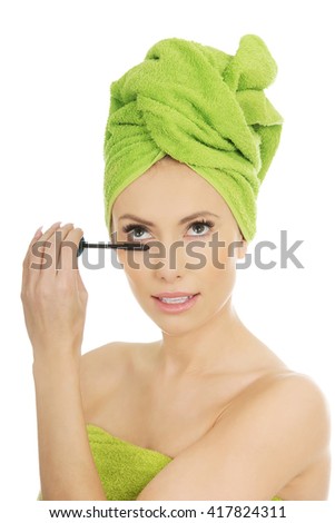 Woman with turban applying make up.